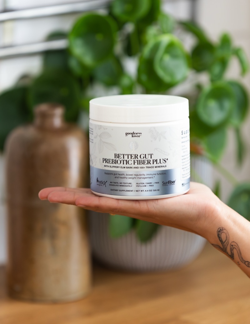 Hand holding Better Gut Prebiotic Fiber Plus jar
