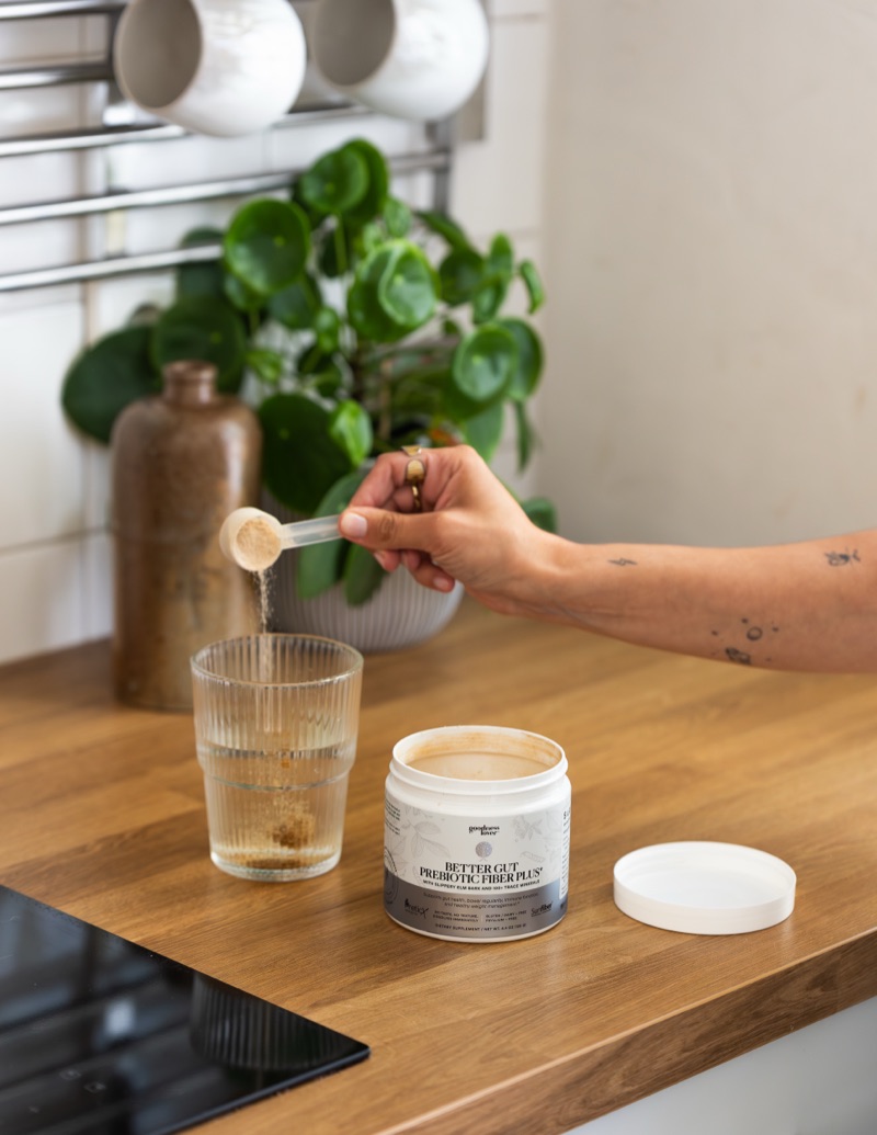 Pouring Better Gut Prebiotic Fiber Plus into a glass of water